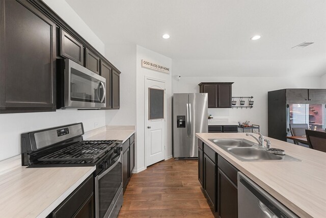 kitchen with stainless steel appliances, dark hardwood / wood-style flooring, sink, and dark brown cabinets