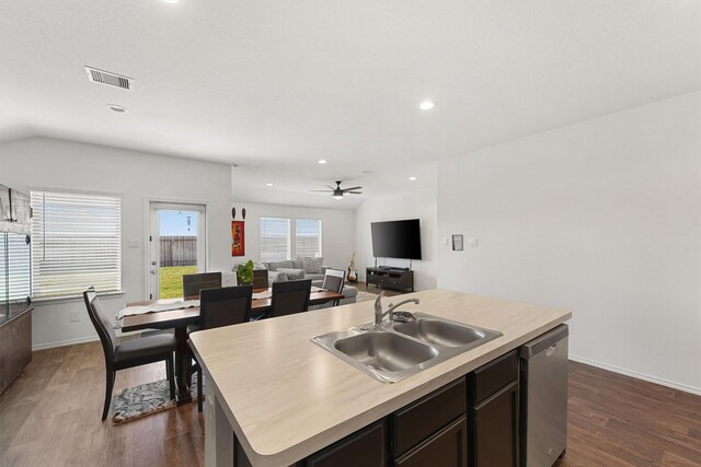 kitchen featuring visible vents, stainless steel dishwasher, dark wood-type flooring, a kitchen island with sink, and a sink