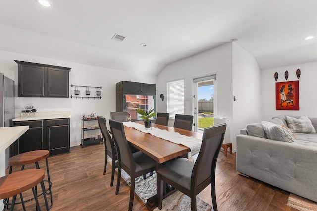 dining space featuring recessed lighting, dark wood-style flooring, visible vents, and vaulted ceiling