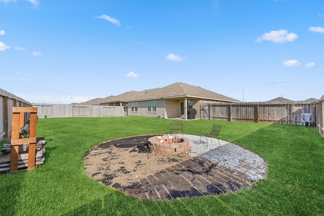 view of yard featuring a fenced backyard and a fire pit