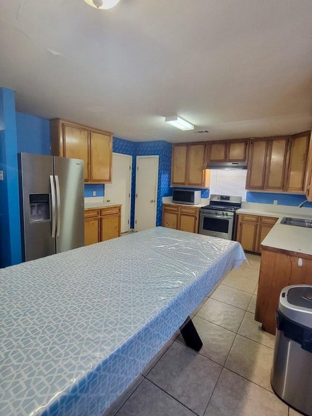 kitchen with sink, light tile patterned floors, and appliances with stainless steel finishes