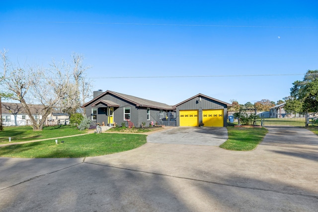 view of front facade with a front yard, an outbuilding, and a garage