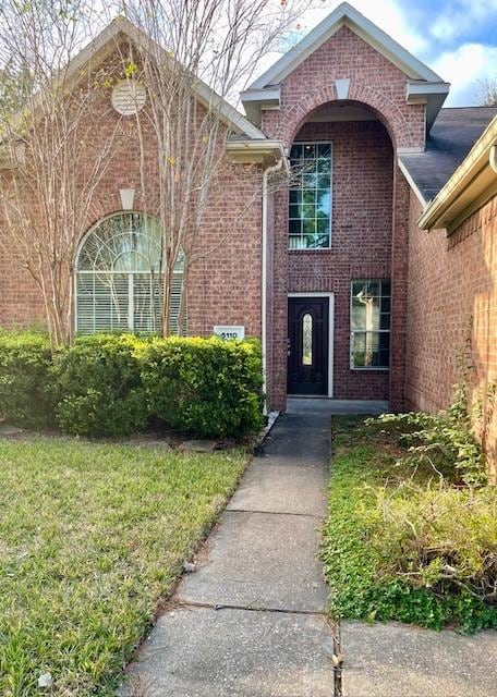 doorway to property featuring a lawn