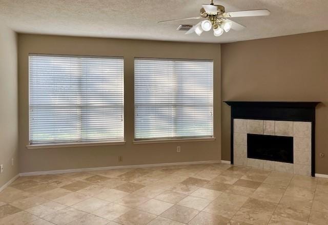 unfurnished living room featuring ceiling fan, a fireplace, and a textured ceiling