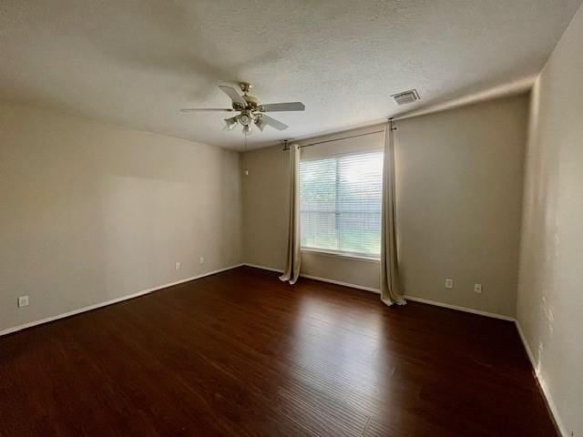 spare room with dark hardwood / wood-style floors, ceiling fan, and a textured ceiling