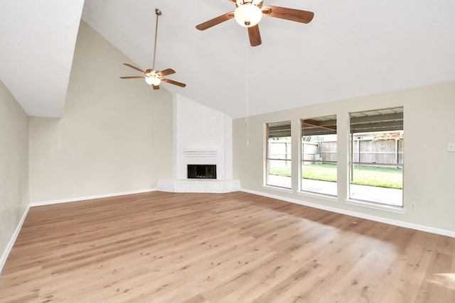 unfurnished living room featuring ceiling fan, a fireplace, and light wood-type flooring