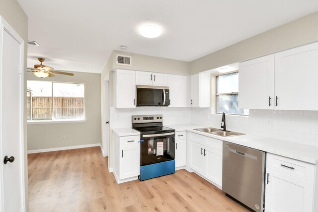 kitchen featuring ceiling fan, sink, stainless steel appliances, white cabinets, and light wood-type flooring