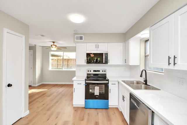 kitchen featuring appliances with stainless steel finishes, sink, white cabinets, and backsplash