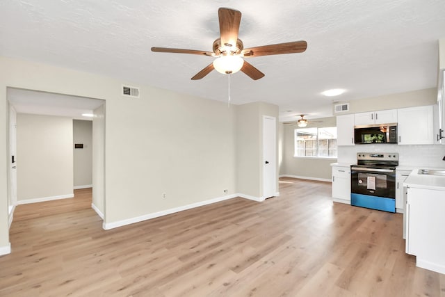 unfurnished living room with ceiling fan, sink, a textured ceiling, and light wood-type flooring