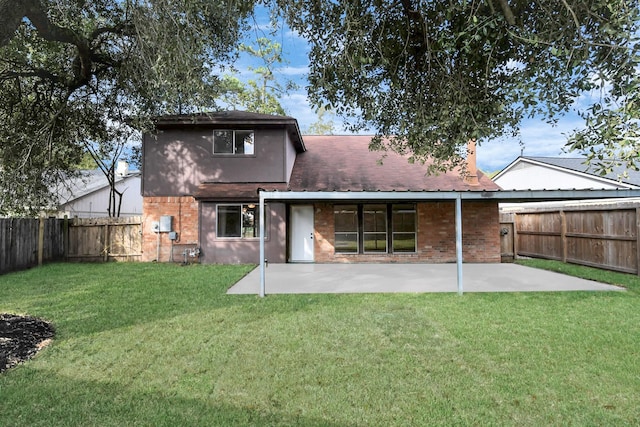 back of property with a yard and a patio