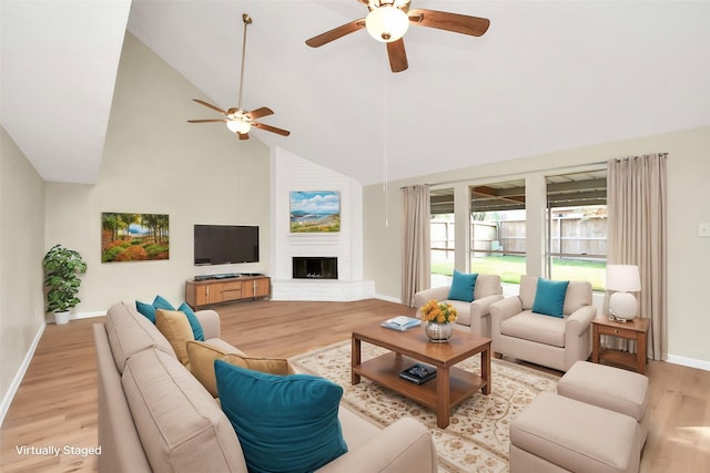 living room with a fireplace, light hardwood / wood-style flooring, high vaulted ceiling, and ceiling fan