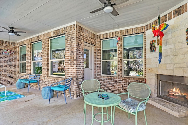 view of patio / terrace with ceiling fan and an outdoor stone fireplace