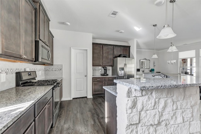 kitchen featuring dark hardwood / wood-style floors, crown molding, stainless steel appliances, and an island with sink