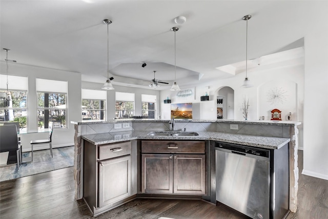 kitchen featuring dark brown cabinetry, hanging light fixtures, stainless steel dishwasher, and dark hardwood / wood-style floors