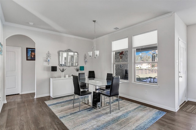 dining space with a fireplace, dark hardwood / wood-style floors, crown molding, and a notable chandelier