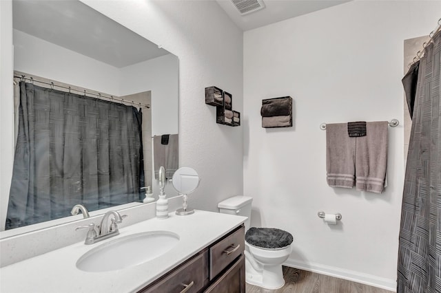 bathroom featuring vanity, hardwood / wood-style flooring, and toilet