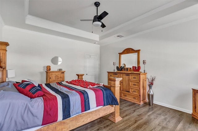 bedroom featuring hardwood / wood-style floors, ceiling fan, a raised ceiling, and crown molding