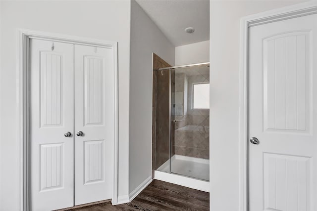 bathroom with an enclosed shower and hardwood / wood-style flooring