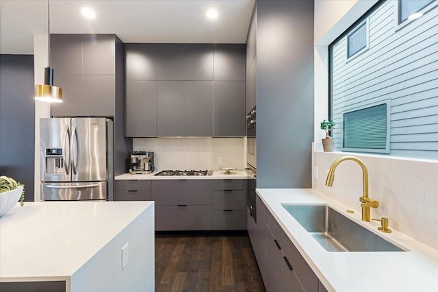 kitchen featuring pendant lighting, gray cabinetry, sink, and appliances with stainless steel finishes