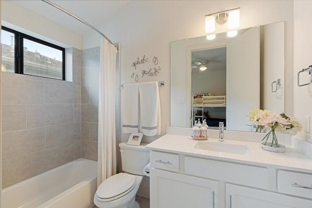 full bathroom with ceiling fan, toilet, vanity, and shower / tub combo with curtain