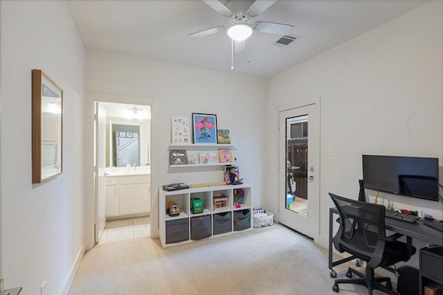 carpeted home office featuring ceiling fan