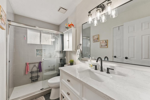 bathroom with vanity, toilet, and a shower with shower door