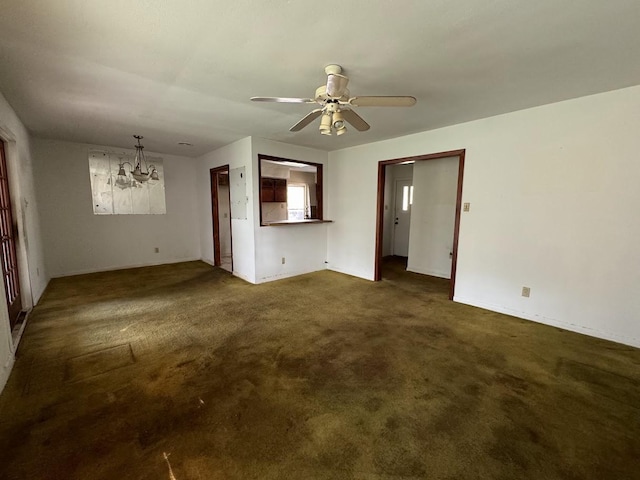 interior space featuring ceiling fan with notable chandelier and dark colored carpet