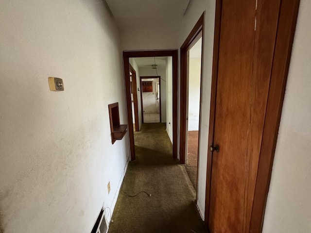 hallway with dark colored carpet