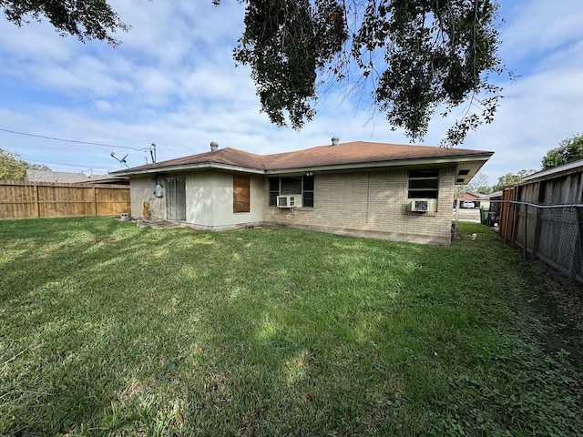 rear view of property with cooling unit and a yard