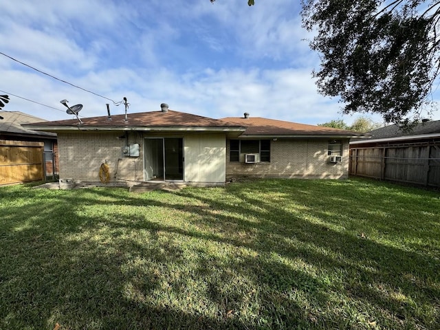 rear view of property with a lawn and cooling unit