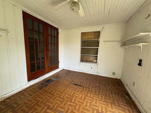 laundry area featuring ceiling fan, built in features, dark parquet floors, and wood walls