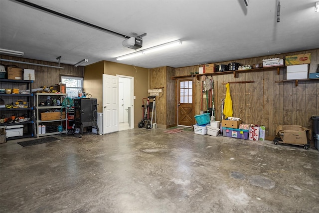 garage featuring wooden walls and a garage door opener