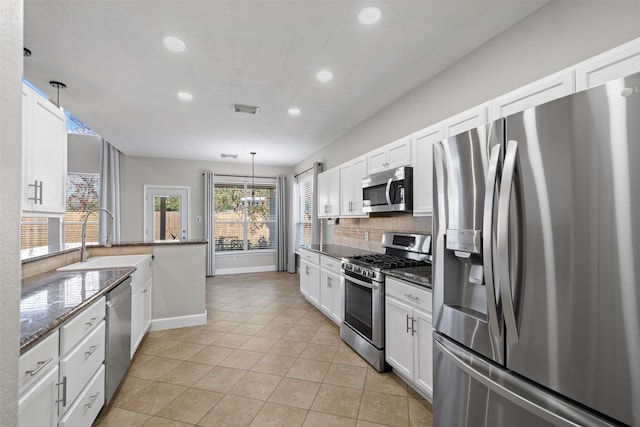 kitchen featuring pendant lighting, white cabinetry, sink, backsplash, and stainless steel appliances