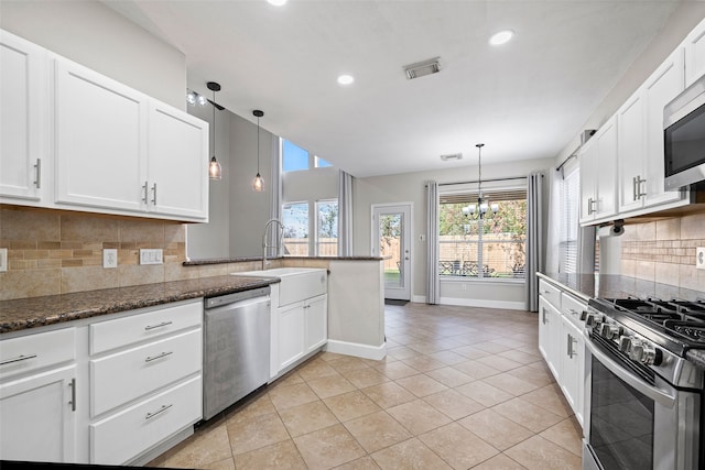 kitchen featuring white cabinetry, hanging light fixtures, stainless steel appliances, and sink