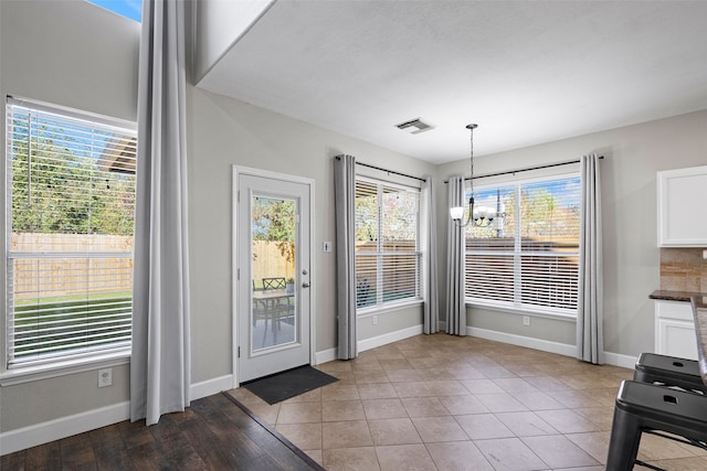 doorway featuring light tile patterned floors and a chandelier