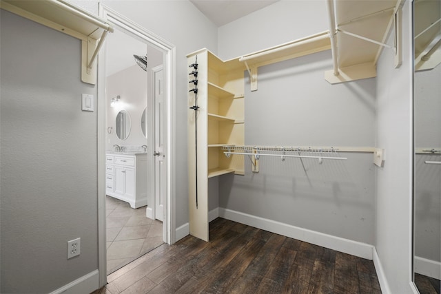 spacious closet with dark hardwood / wood-style flooring and sink