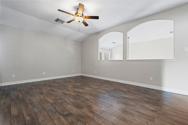 empty room featuring vaulted ceiling, dark hardwood / wood-style floors, and ceiling fan