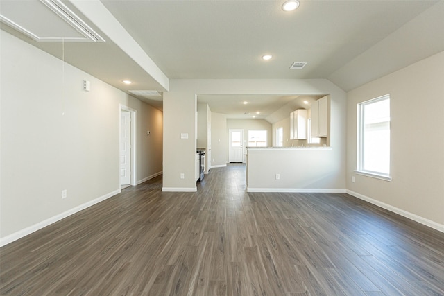 unfurnished living room featuring a wealth of natural light, dark hardwood / wood-style flooring, and lofted ceiling