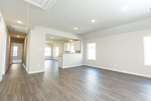 unfurnished living room featuring dark hardwood / wood-style flooring and a wealth of natural light