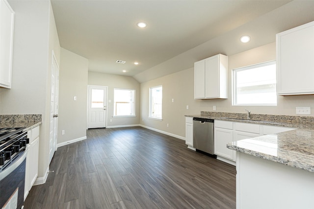 kitchen featuring white cabinets, light stone counters, stainless steel appliances, and dark wood-type flooring