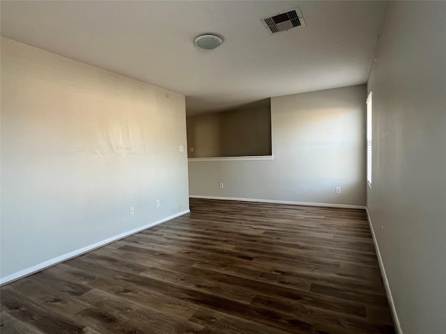 unfurnished room with dark wood-type flooring