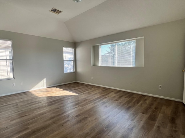 spare room with dark hardwood / wood-style floors and vaulted ceiling