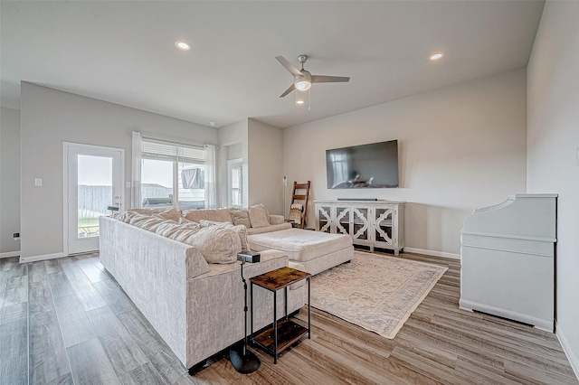 living room featuring ceiling fan and light hardwood / wood-style floors