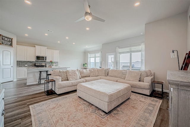 living room with wood-type flooring and ceiling fan