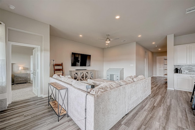 living room featuring light hardwood / wood-style flooring and ceiling fan