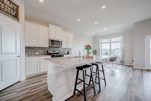 kitchen with white cabinetry, sink, an island with sink, and appliances with stainless steel finishes