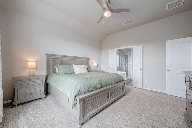 bedroom featuring ensuite bathroom, lofted ceiling, light carpet, and ceiling fan