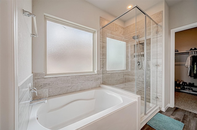 bathroom featuring hardwood / wood-style flooring and separate shower and tub