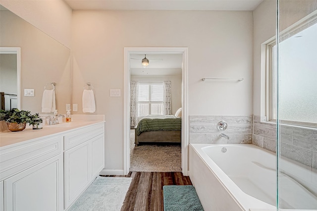 bathroom with hardwood / wood-style flooring, vanity, and a bath