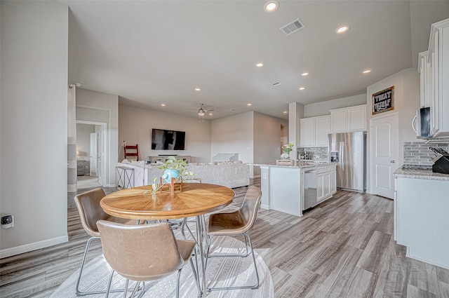 dining room with ceiling fan and light wood-type flooring